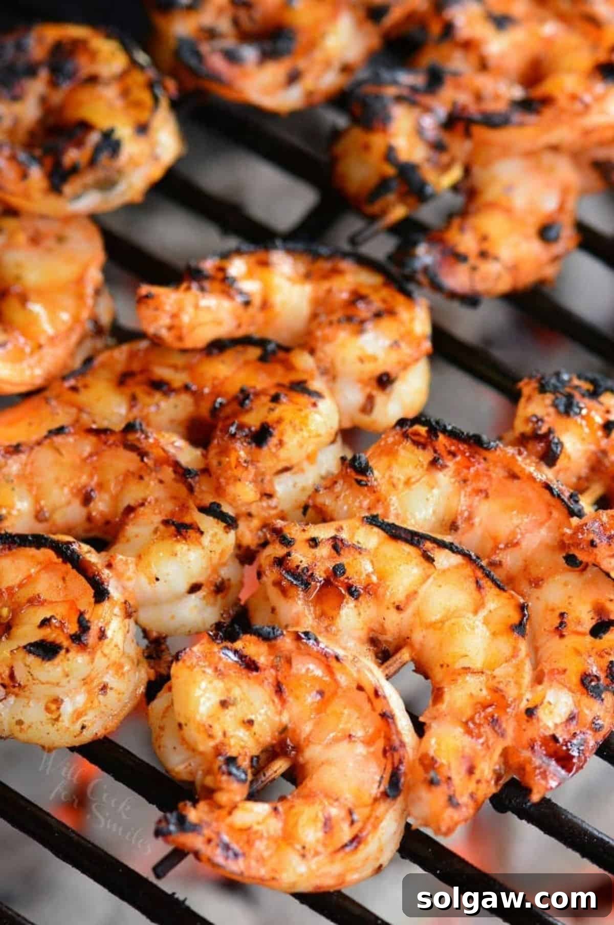 Zesty Cajun Grilled Shrimp & Garden Vegetables 7 Close-up of vibrant Cajun seasoned shrimp skewers cooking on a charcoal grill, showing perfect char marks and smoky appeal