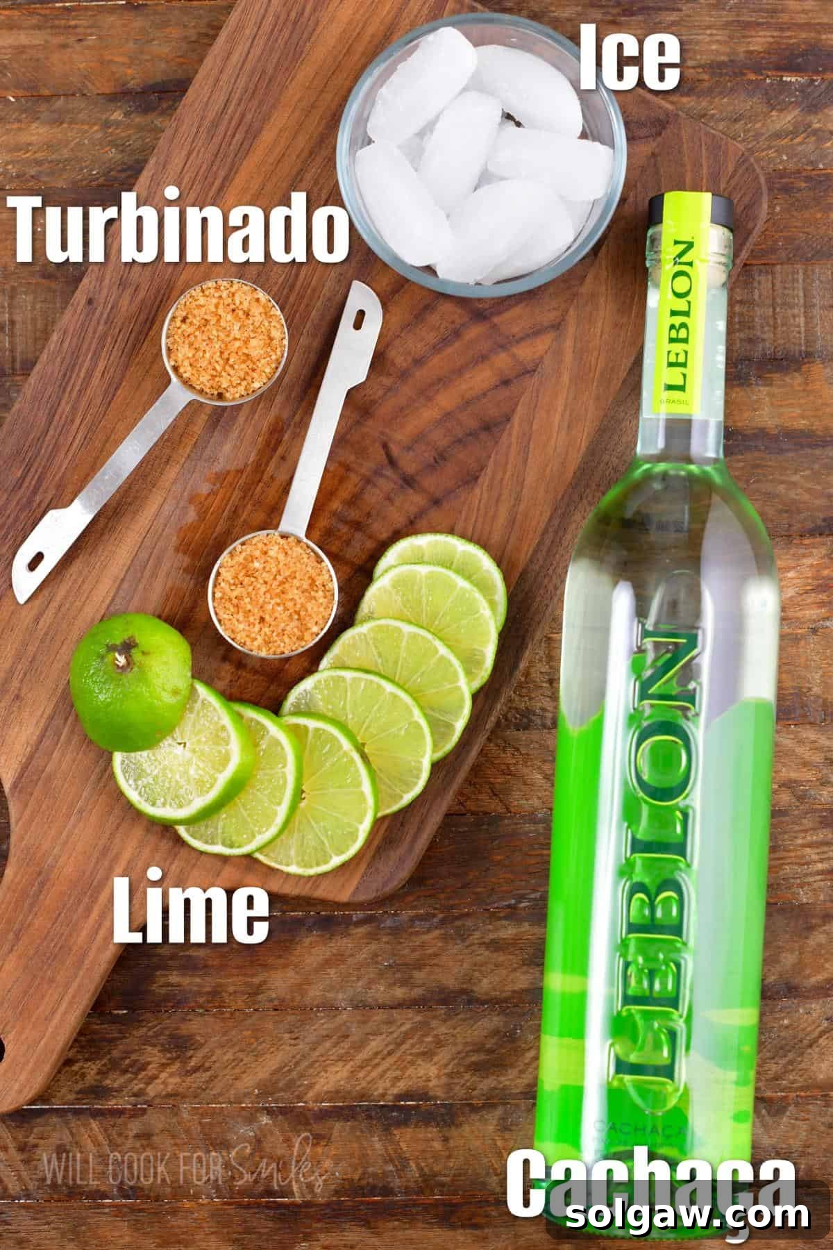 Labeled ingredients for a Caipirinha cocktail including Cachaca, limes, and sugar on a wooden surface.