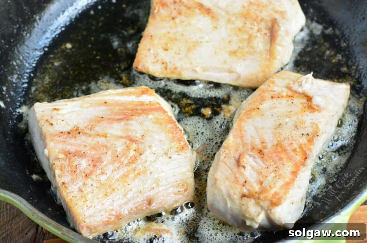 Golden Pan Seared Mahi Mahi with Bursting Tomato Basil 4 searing three mahi mahi filets on the skillet in butter and seasoning.