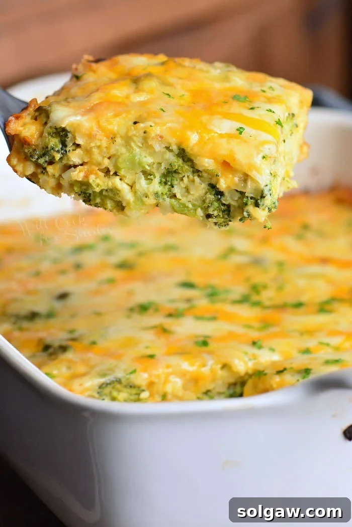 Golden Hash Brown, Broccoli, and Cheese Bake 7 taking out a slice of broccoli cheese hashbrown casserole from the baking dish.