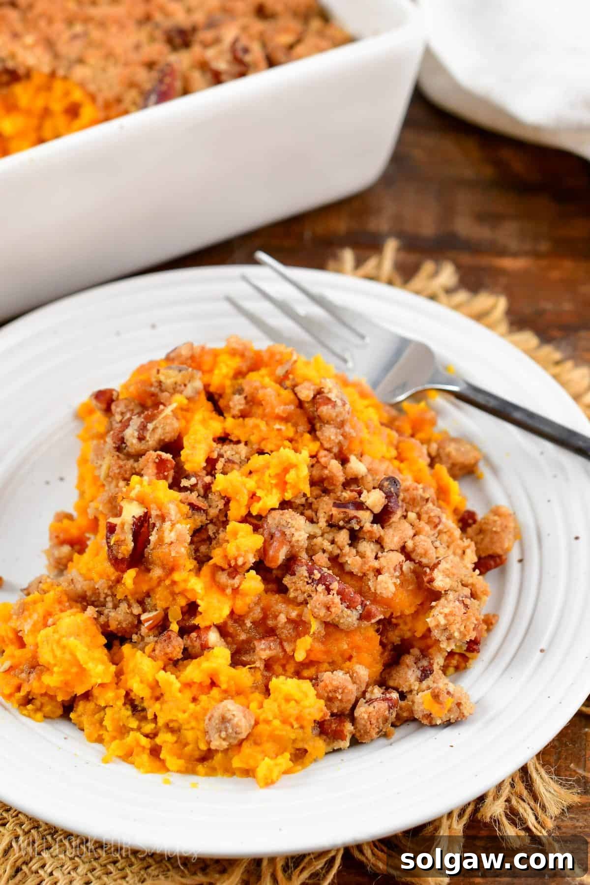 portion of a sweet potato casserole with a pecan crumble topping.