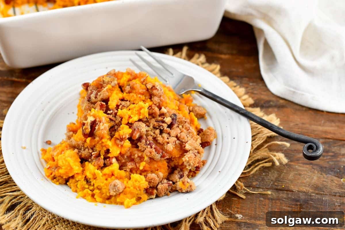 sweet potato casserole on a white plate with a fork.