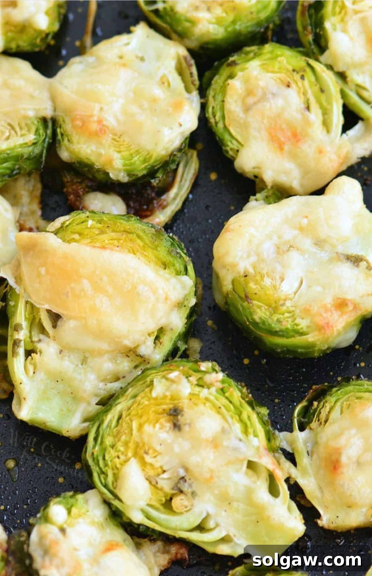 Mouthwatering Parmesan Roasted Brussels Sprouts with melted cheese on a baking sheet.