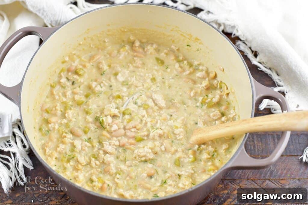 Finished White Turkey Chili in a pot, topped with fresh cilantro.