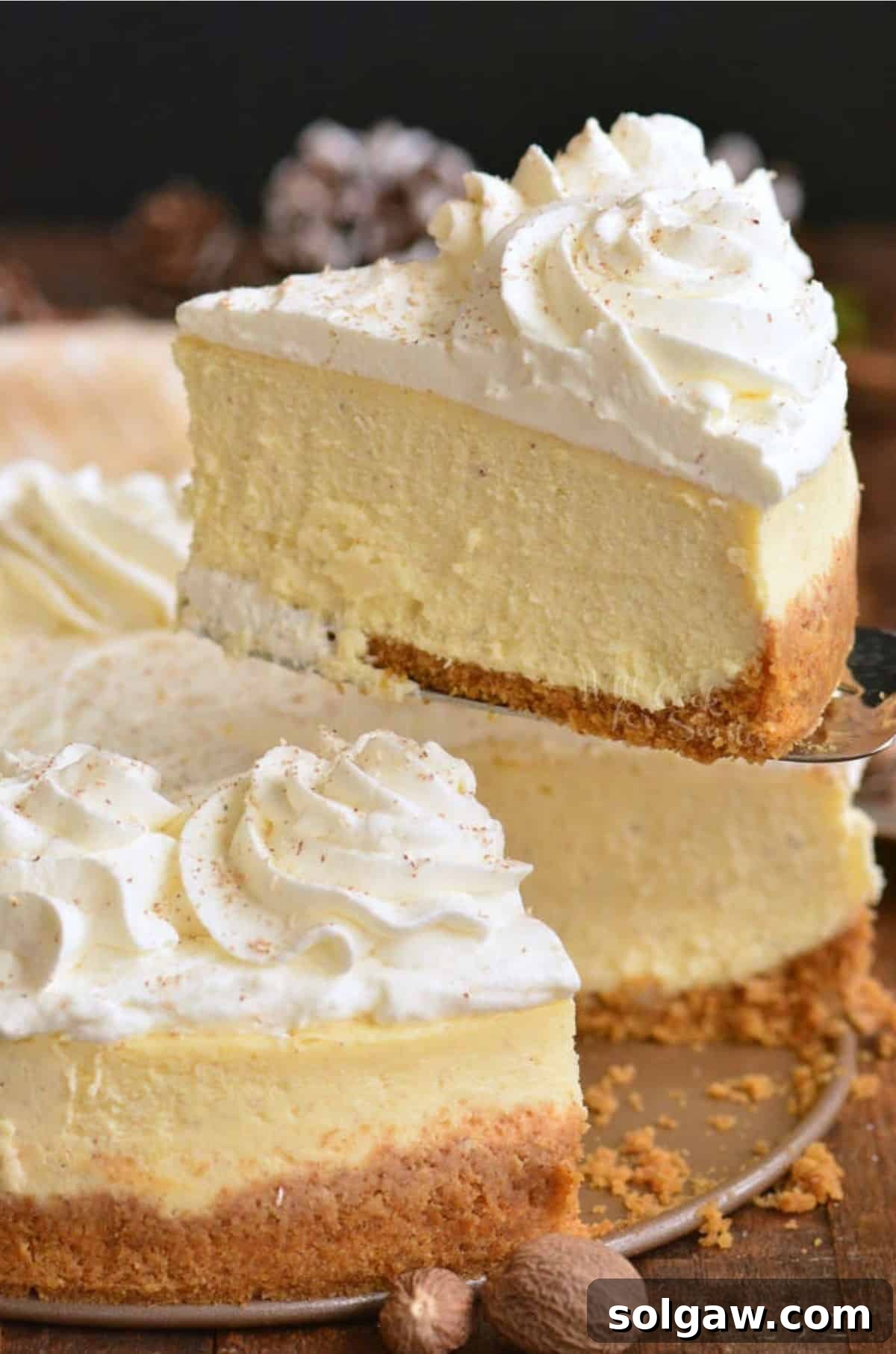 Yuletide Eggnog Cheesecake 2 A beautiful slice of creamy eggnog cheesecake being served, showcasing its rich texture and festive topping.