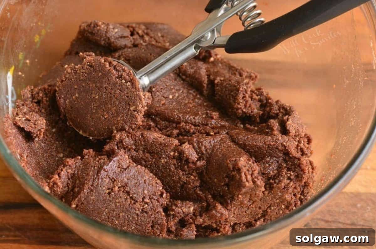 Heavenly Homemade Rum Balls 4 Mixture for rum balls in a clear bowl, ready to be scooped with a cookie scoop.