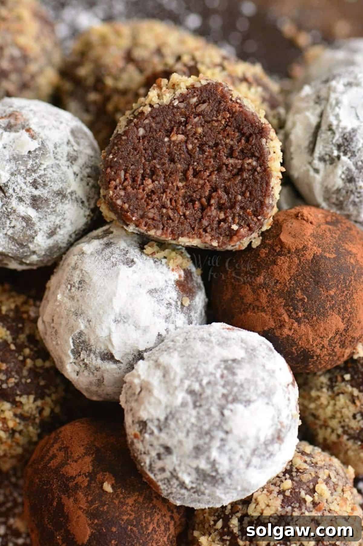 Heavenly Homemade Rum Balls 7 Several stacked rum balls with one perfectly cut in half to reveal its rich, chewy interior.