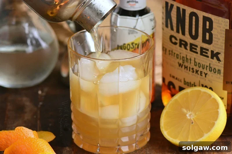 Whiskey Sour Two Takes 5 Pouring the mixed Whiskey Sour cocktail through a strainer into a glass.
