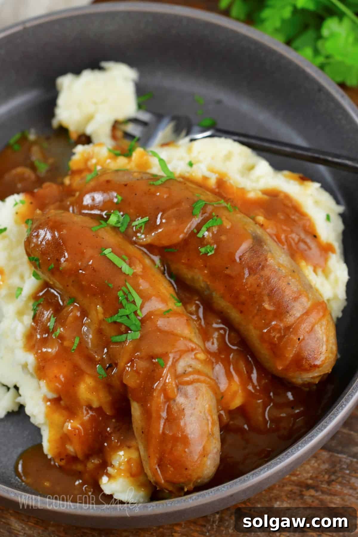 Onion Gravy Smothered Sausages and Mash 7 two sausages with gravy and mashed potatoes.