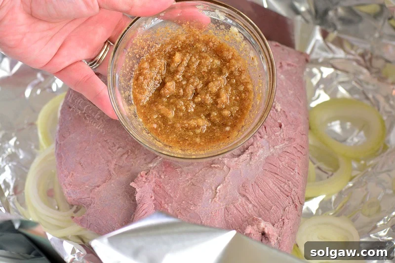 One-Pan Corned Beef with Crispy Potatoes 4 Close-up shot of the vibrant mustard rub ingredients mixed in a small bowl, showcasing the textures and colors of garlic, ground mustard, and coriander.
