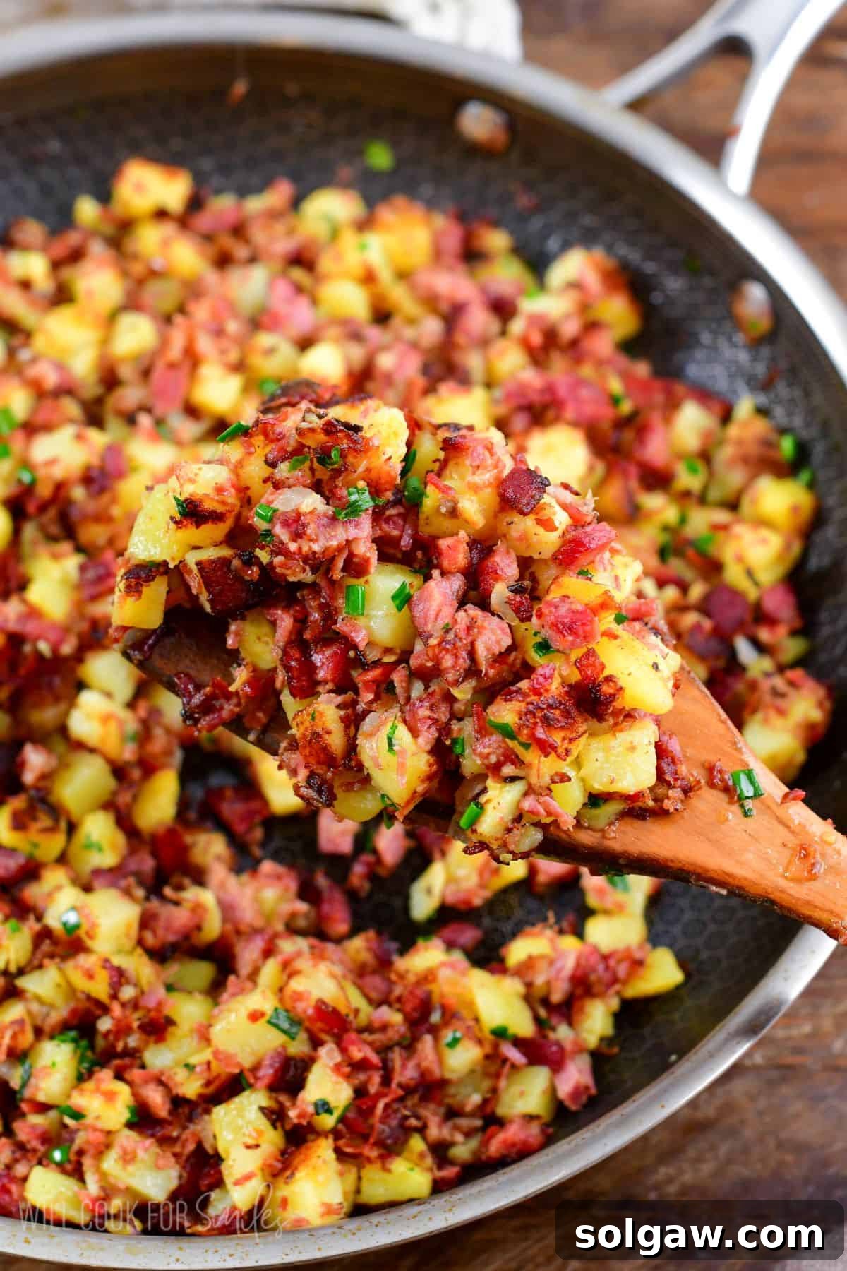 Scooping corn beef hash out of a pan.