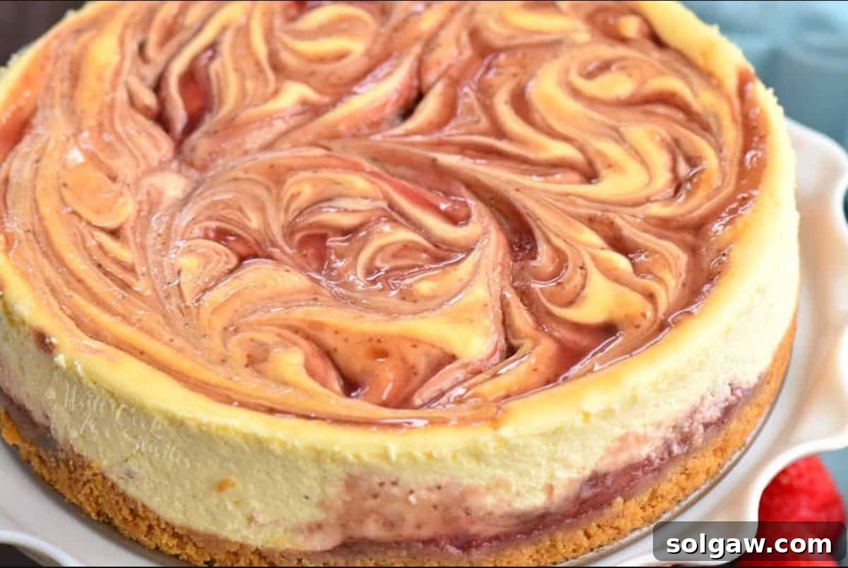 A perfect slice of strawberry cheesecake served on a white plate, highlighting the beautiful swirl.