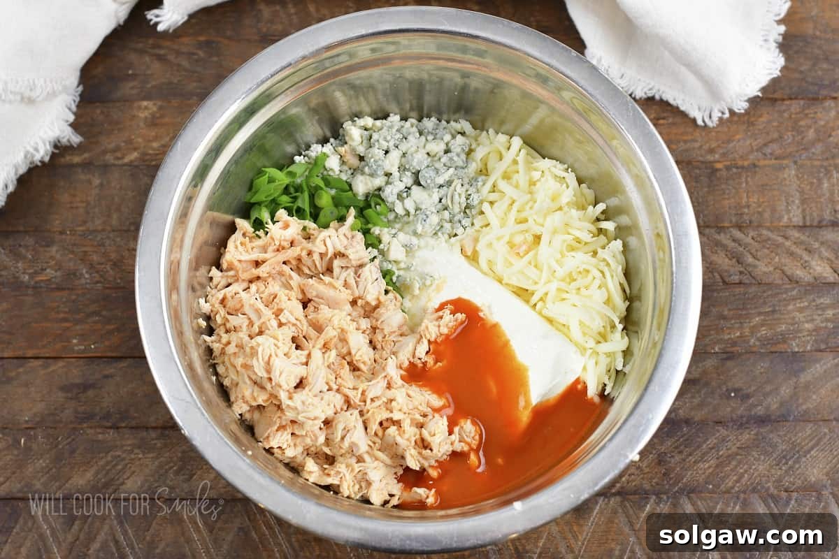 All ingredients for Buffalo Chicken Dip mixed together in a large bowl.