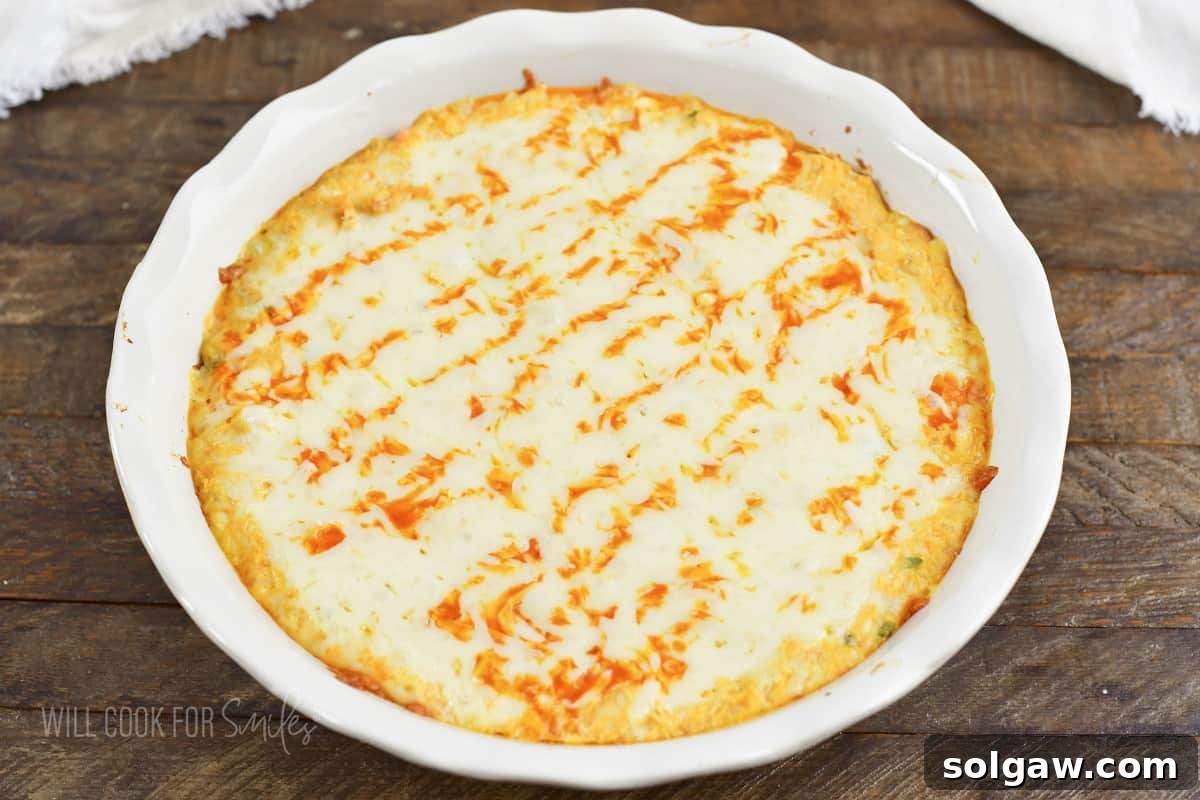Freshly baked Buffalo Chicken Dip in a white baking dish, ready to serve.