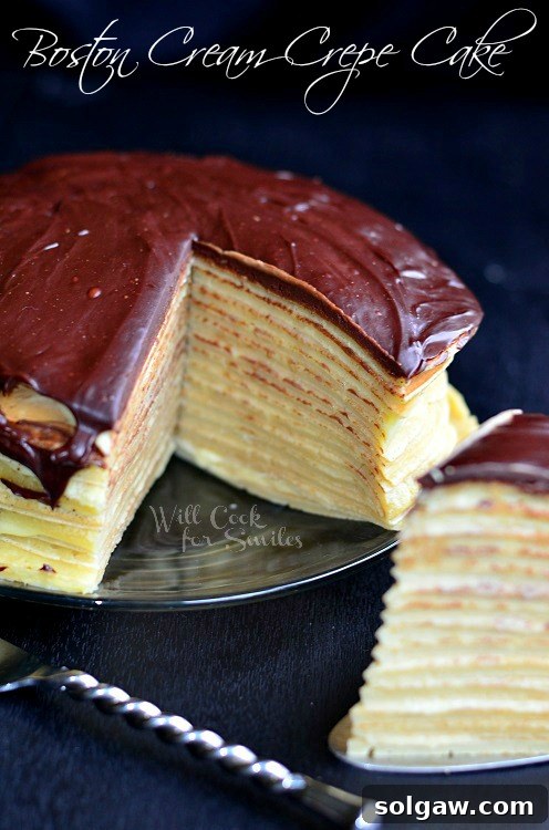 Boston Cream Mille Crepe 6 A slice of Boston Cream Crepe Cake on a cake cutter, ready to be served, with the full cake visible in the background on a black countertop.