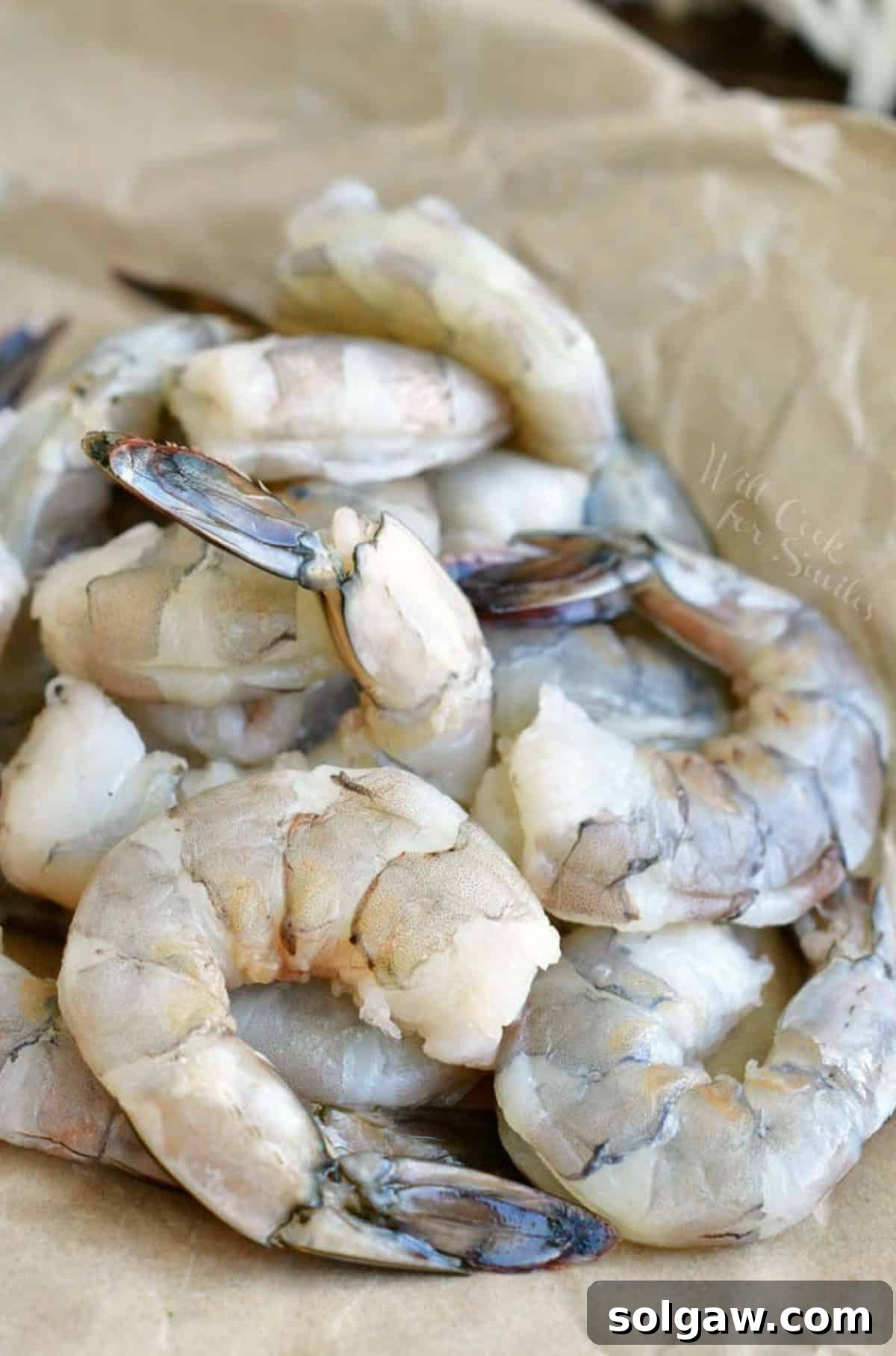 peeled and devievned shrimp laying on parchement paper.