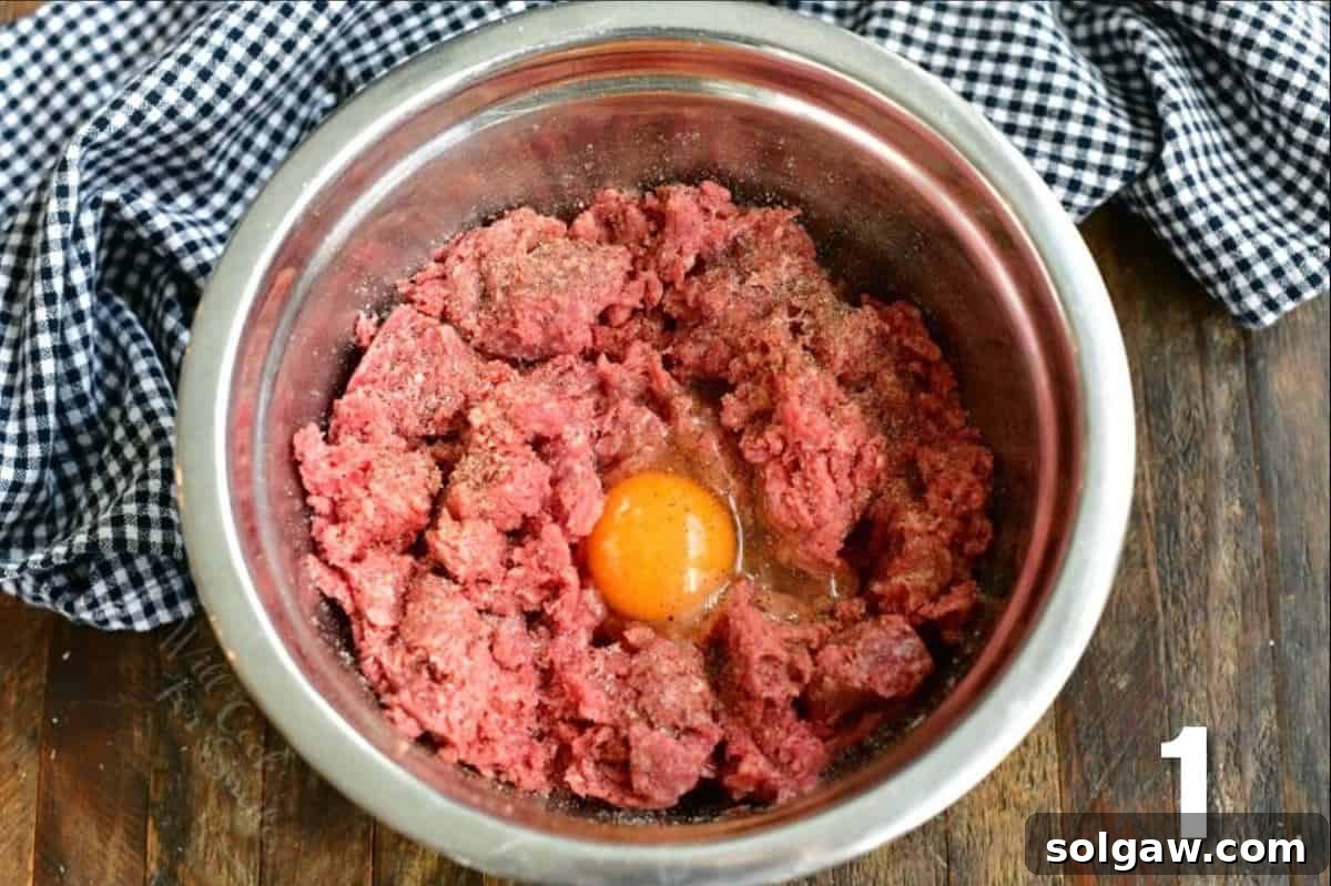 Crafting the Ultimate Burger 3 Ground beef in a mixing bowl with an egg, salt, and pepper, ready for blending.