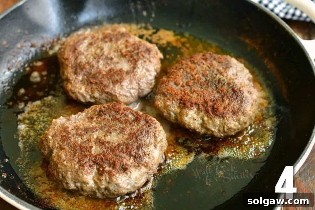 Crafting the Ultimate Burger 6 Three juicy burger patties sizzling in a hot skillet, nearing perfection.