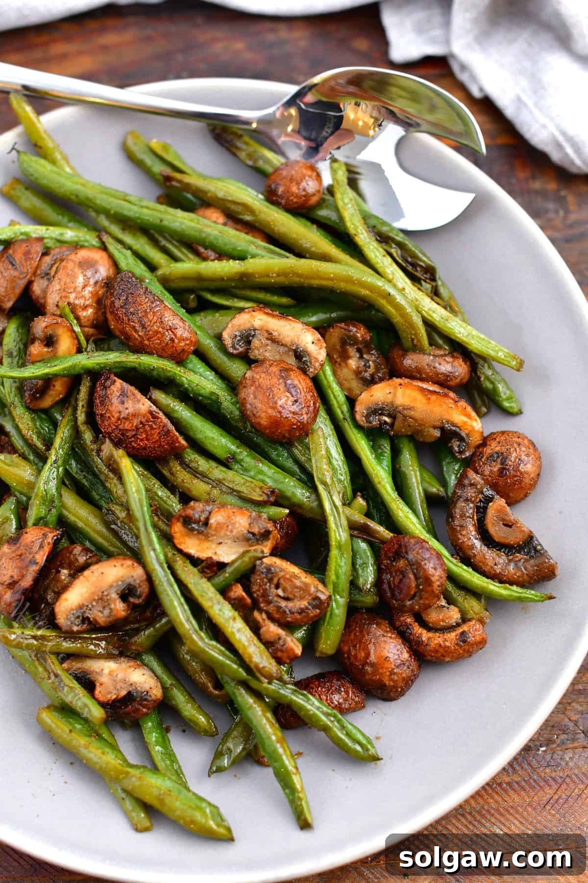 Savory Mushroom and Green Bean Roast 3 An overhead view of a serving bowl filled with perfectly roasted green beans and mushrooms.