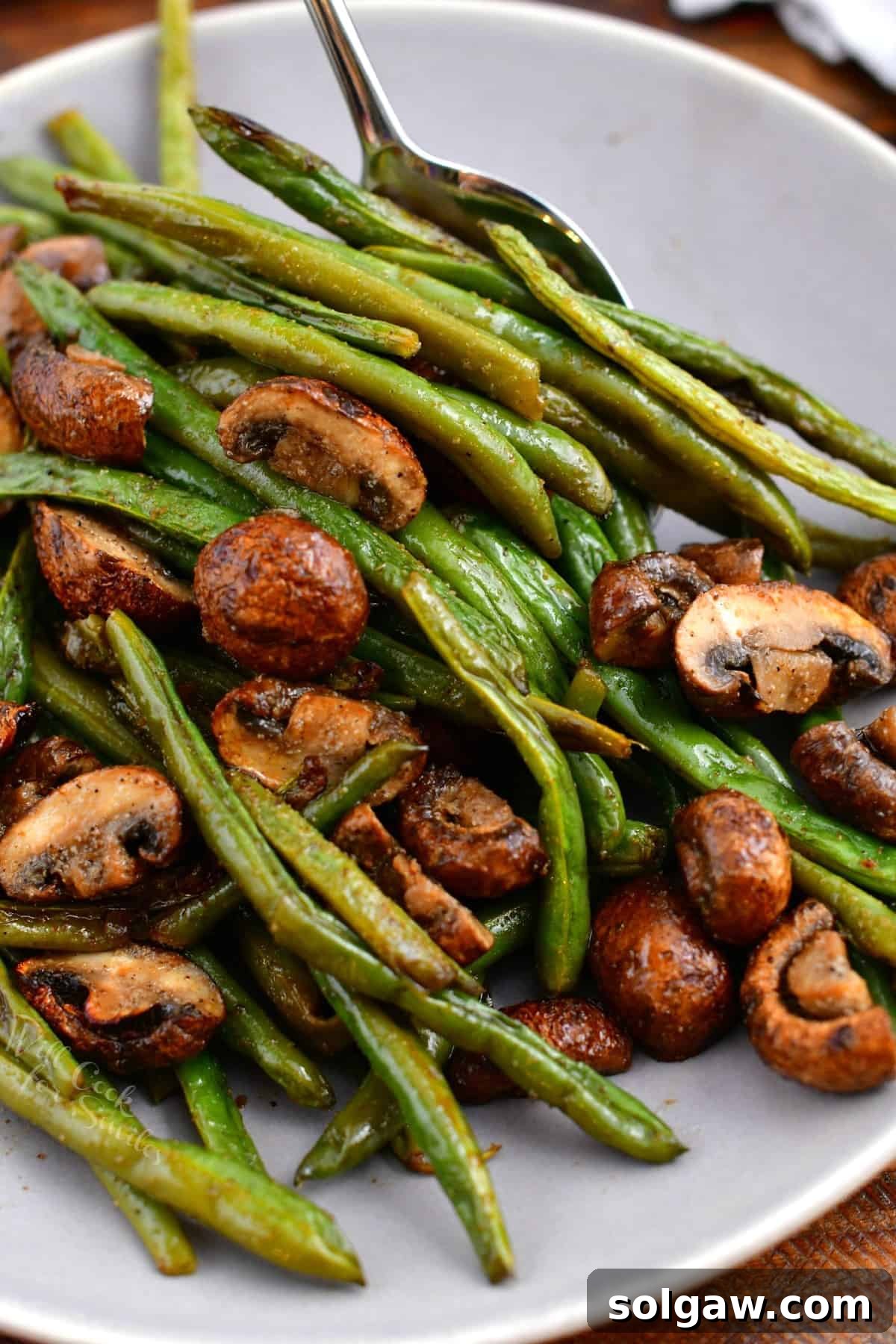 Savory Mushroom and Green Bean Roast 7 A close-up, overhead photo showing a white bowl of tender string beans with perfectly sautéed mushrooms.