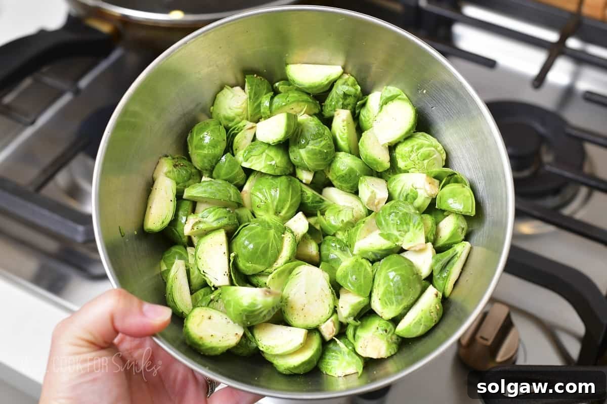Cut Brussels sprouts seasoned with salt and pepper in a bowl, ready for the pan.