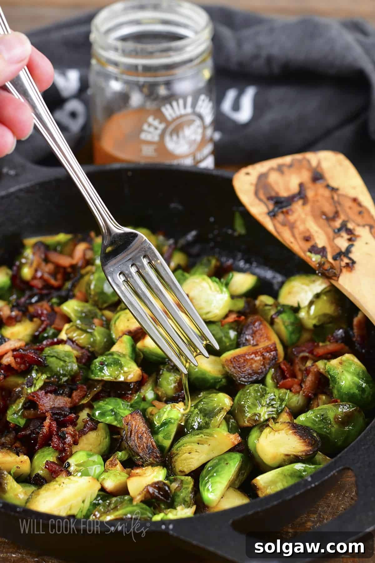 Drizzling extra honey over a serving of roasted Brussels sprouts, enhancing their natural sweetness.