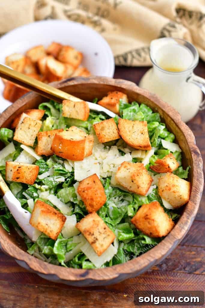 Homemade Caesar salad with garlic croutons and creamy dressing in a rustic wooden bowl