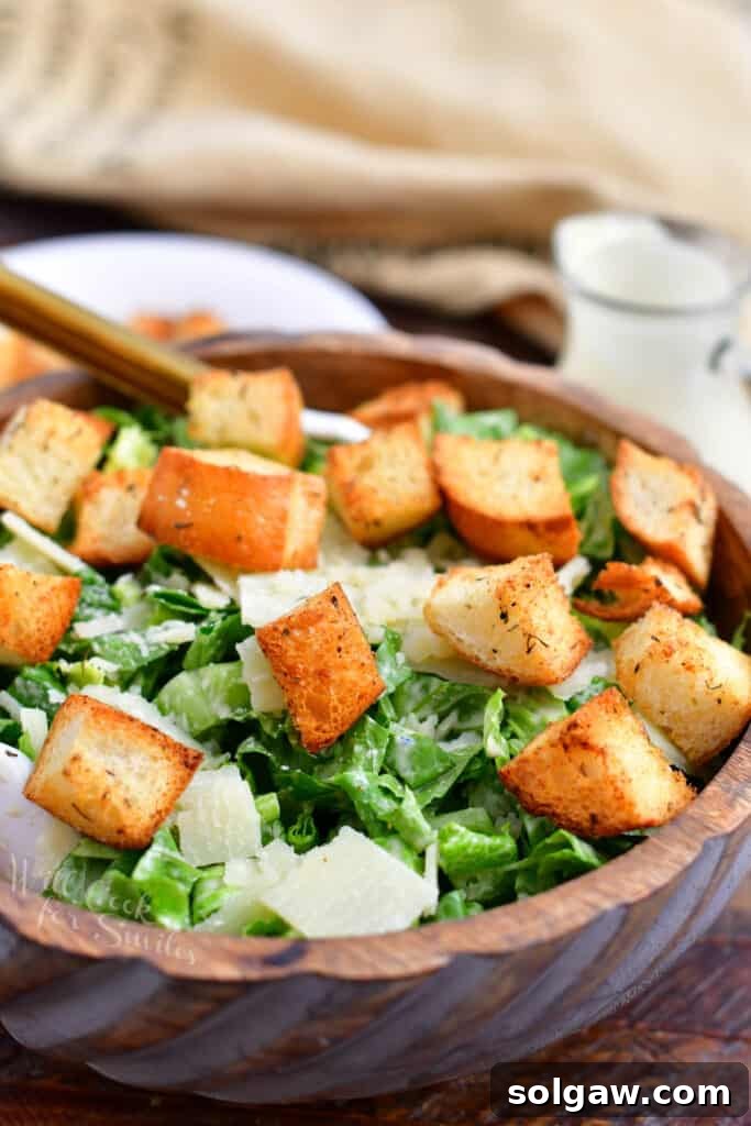 A beautifully presented bowl of homemade Caesar salad, topped with garlic croutons and shaved Parmesan