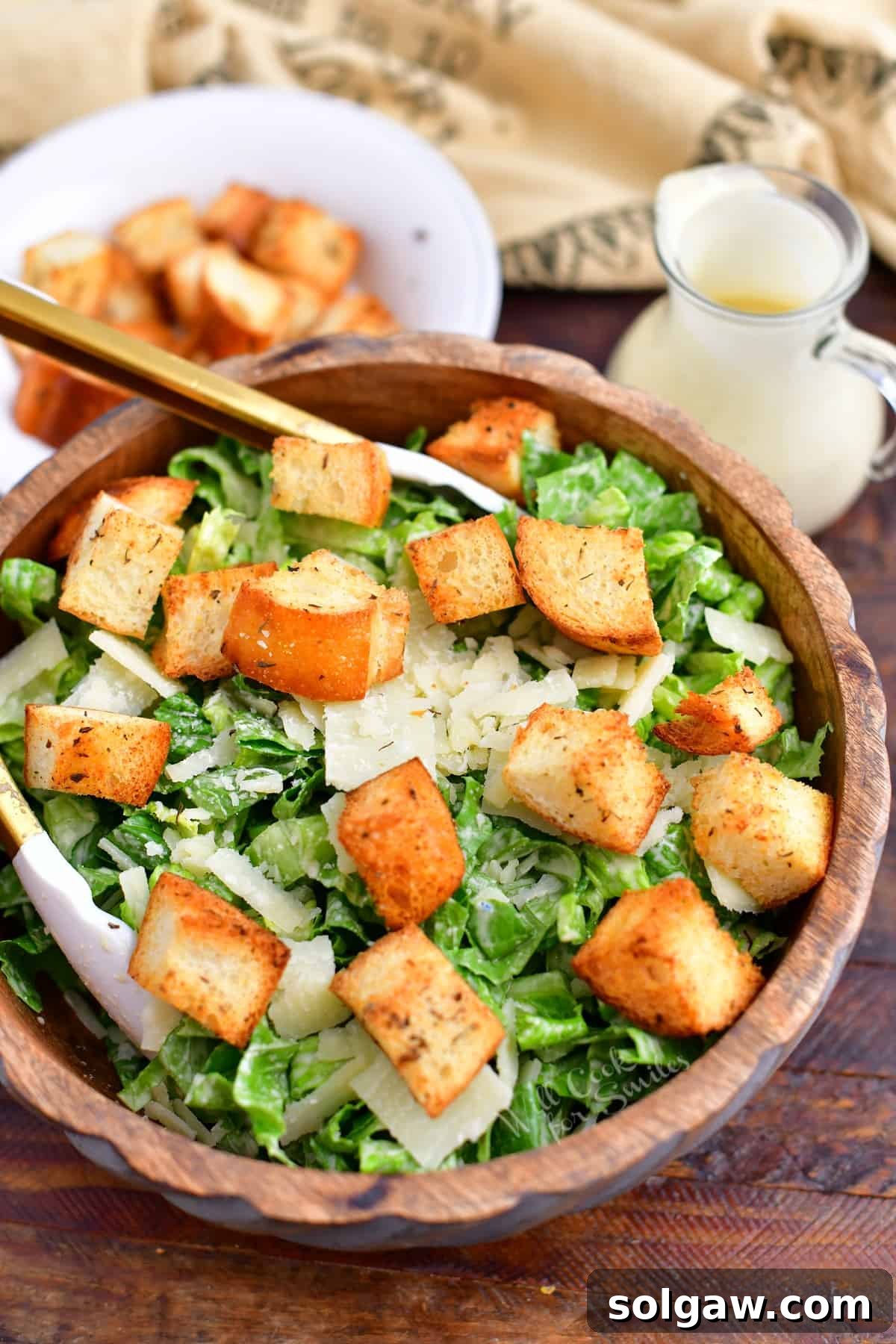 Homemade Caesar salad with garlic croutons and dressing in a wooden bowl