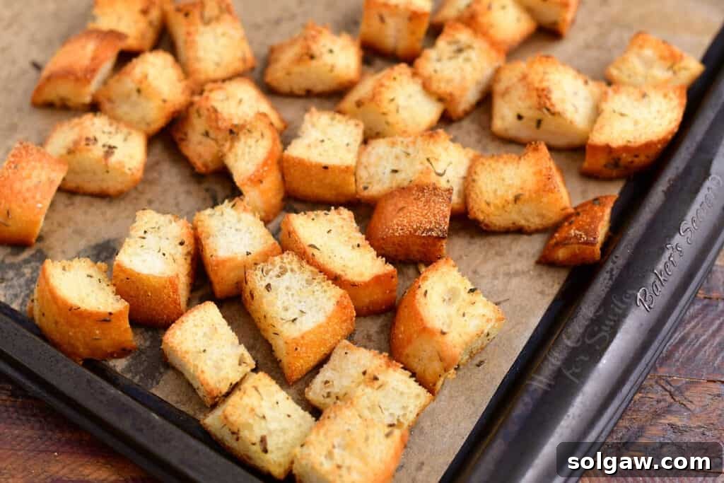 Golden brown, crispy homemade croutons cooling on a baking sheet after being toasted to perfection