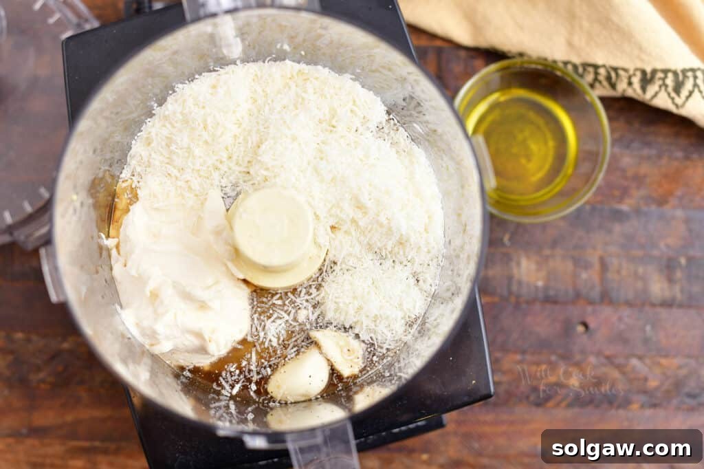 Ingredients for homemade Caesar salad dressing being prepared in a food processor