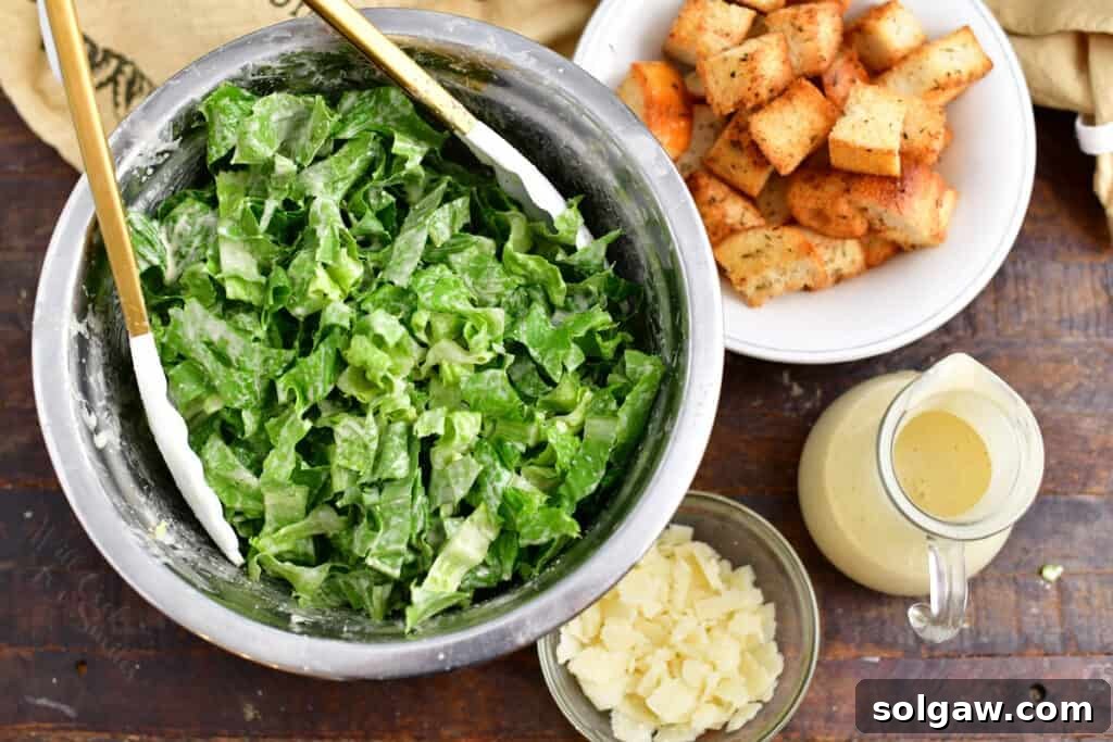 Tossing a fresh classic Caesar salad with dressing in a large mixing bowl for even coating