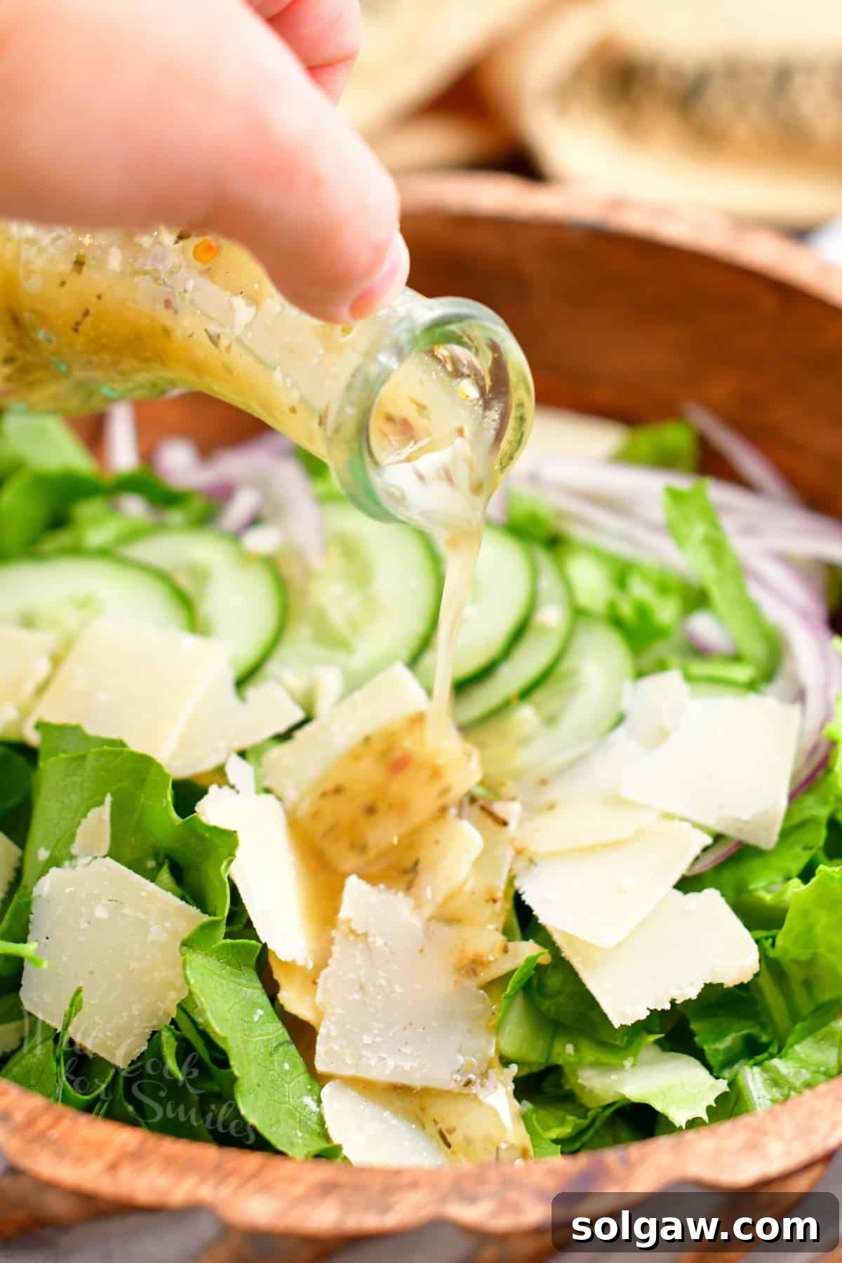 Zesty Italian Vinaigrette 8 pouring homemade Italian dressing onto a fresh green salad.