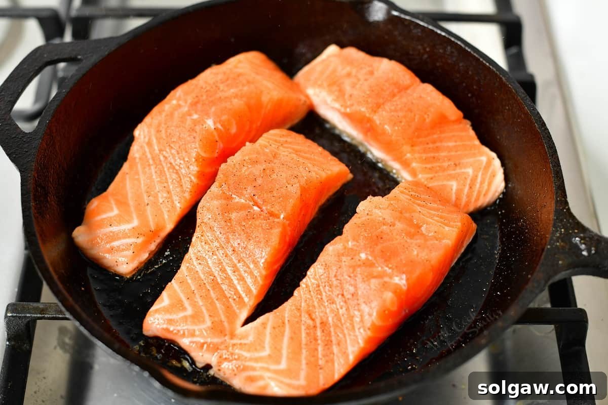 Sticky Sweet Teriyaki Salmon 4 pan searing salmon fillets in a cast iron skillet