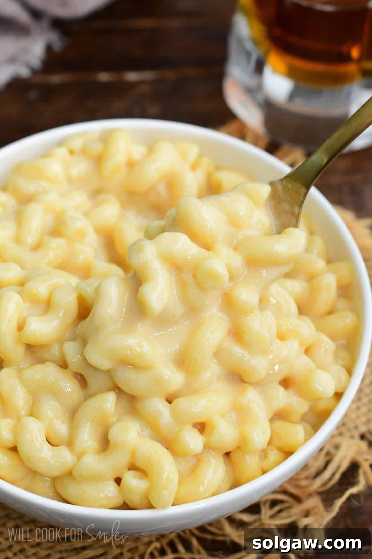 Craft Beer Mac and Cheese 2 Creamy beer macaroni and cheese in a bowl with a spoon lifting cheesy elbow pasta.