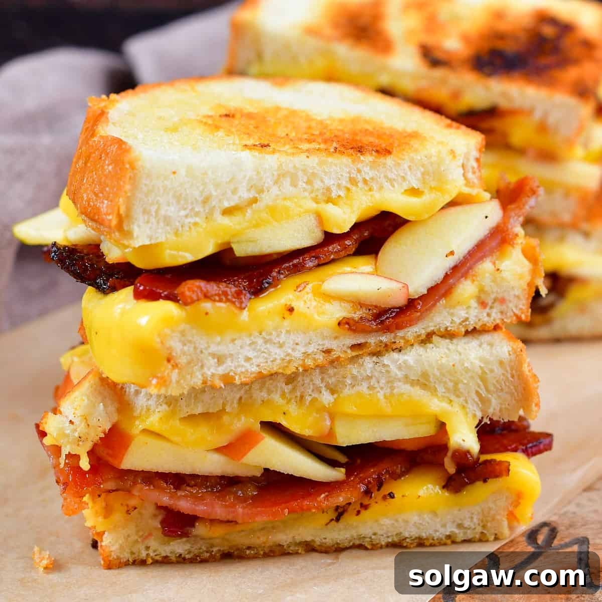 Squared centered image of stacked apple bacon grilled cheese