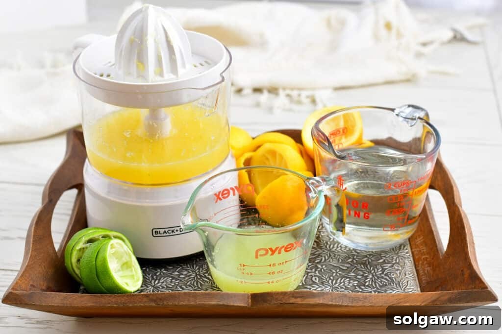 Two glass measuring cups, one filled with freshly squeezed lemon and lime juice, and the other with clear simple syrup. Both are ready to be combined into the sweet and sour mix.