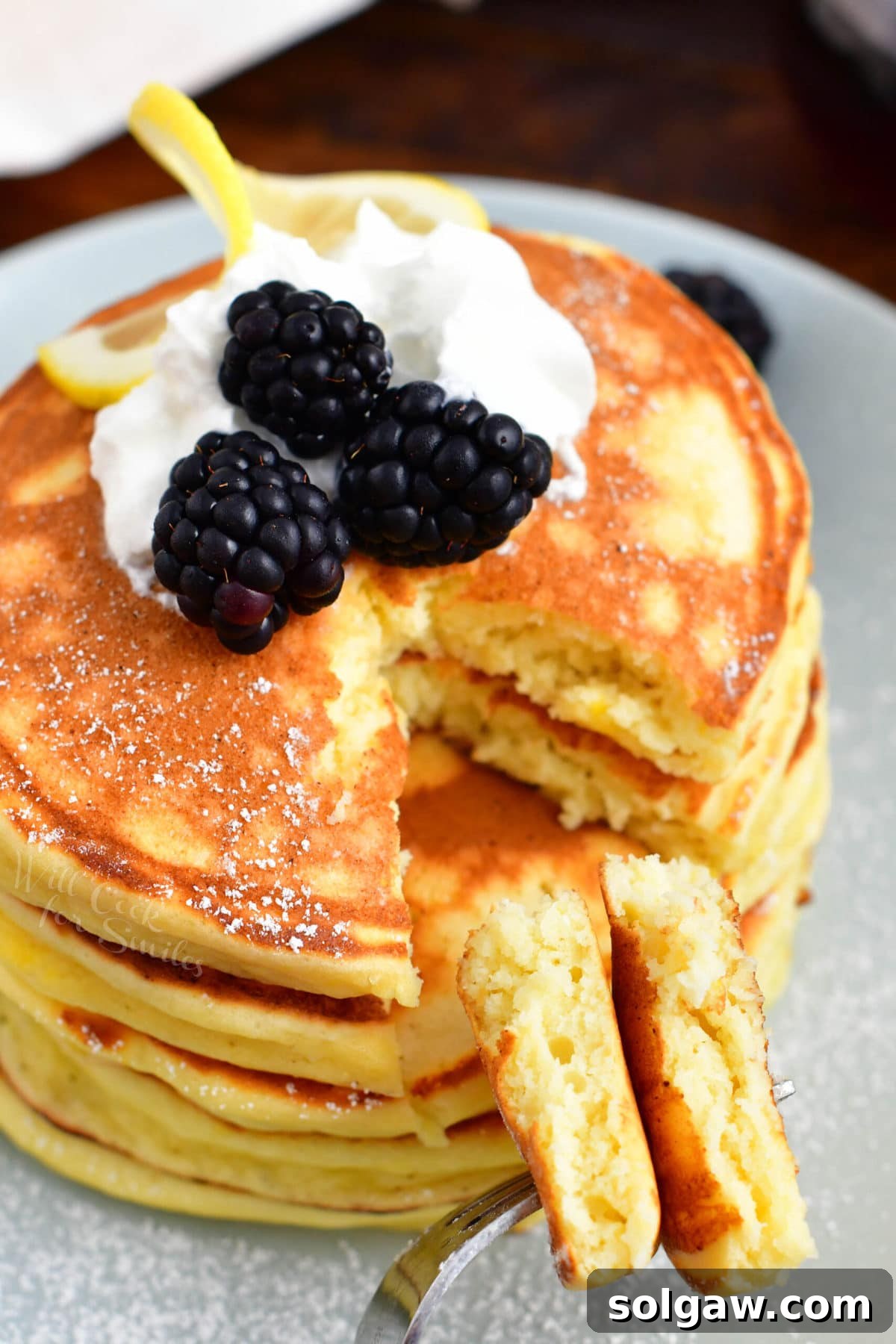 Cloud-Like Ricotta Pancakes 7 A small bite sized piece of pancake has been cut out of the stack.