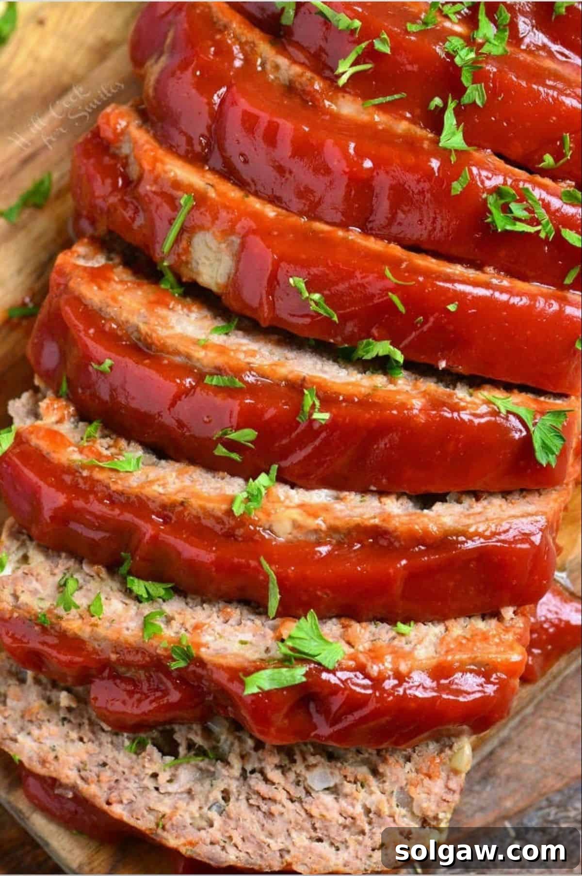 Several slices of perfectly cooked, juicy meatloaf topped with a rich ketchup glaze, ready to serve.