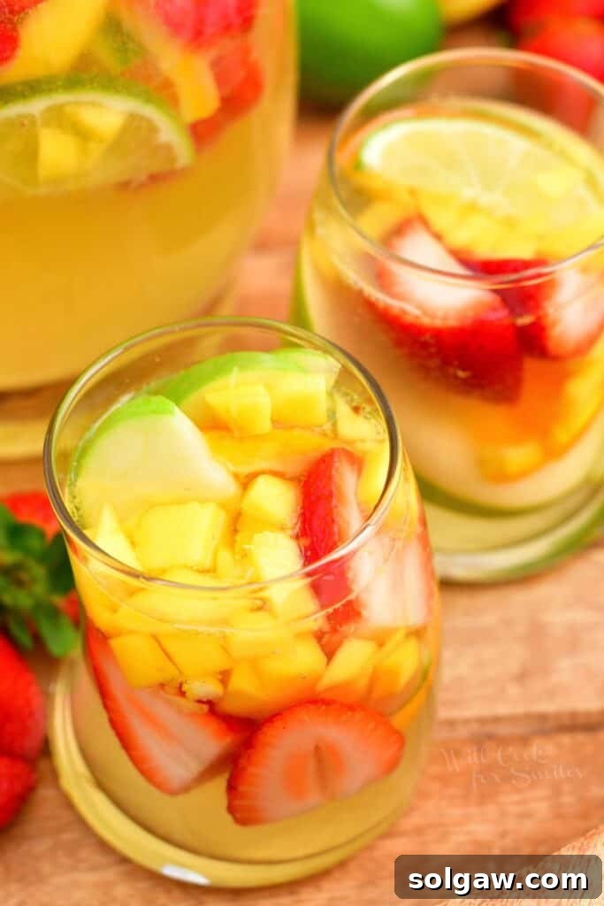 Summer's Perfect White Sangria 8 Two elegant glasses brimming with colorful fruit and chilled white sangria, ready to be enjoyed.