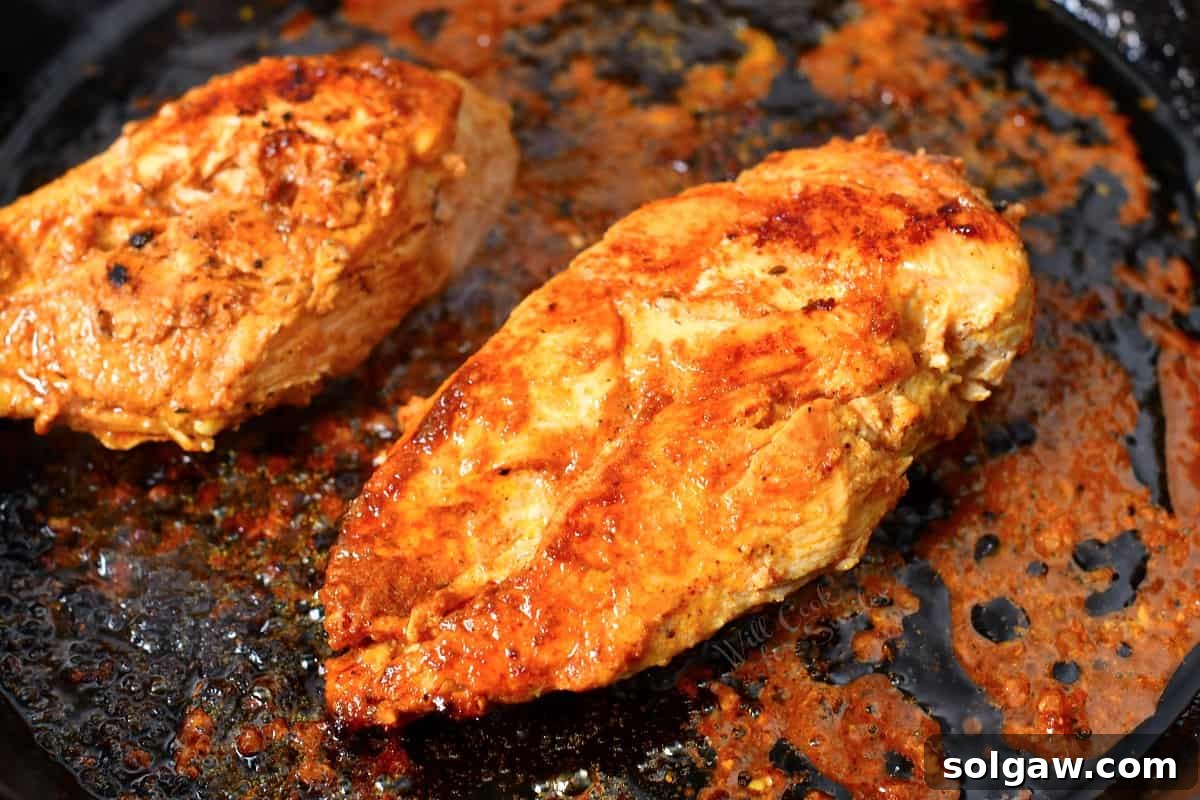 Sizzling Chicken Fajitas 8 Chicken strips cooking in a skillet, developing a golden-brown crust.