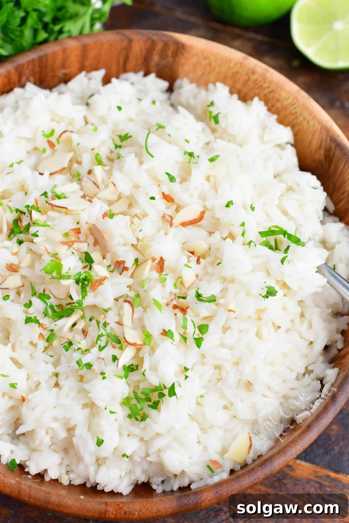 Coconut rice is fluffed and presented in a large serving bowl.