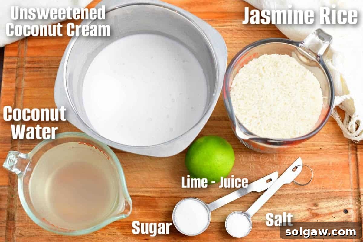Fragrant Coconut Rice 3 Labeled ingredients for coconut rice on a wooden cutting board, including jasmine rice, cans of coconut cream and coconut water, and fresh lime.
