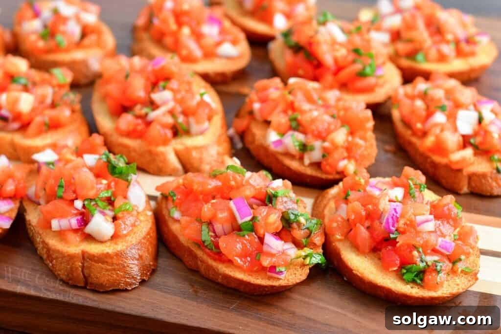 Sliced toasted bread laid out on a cutting board, ready to be topped with tomato mixture