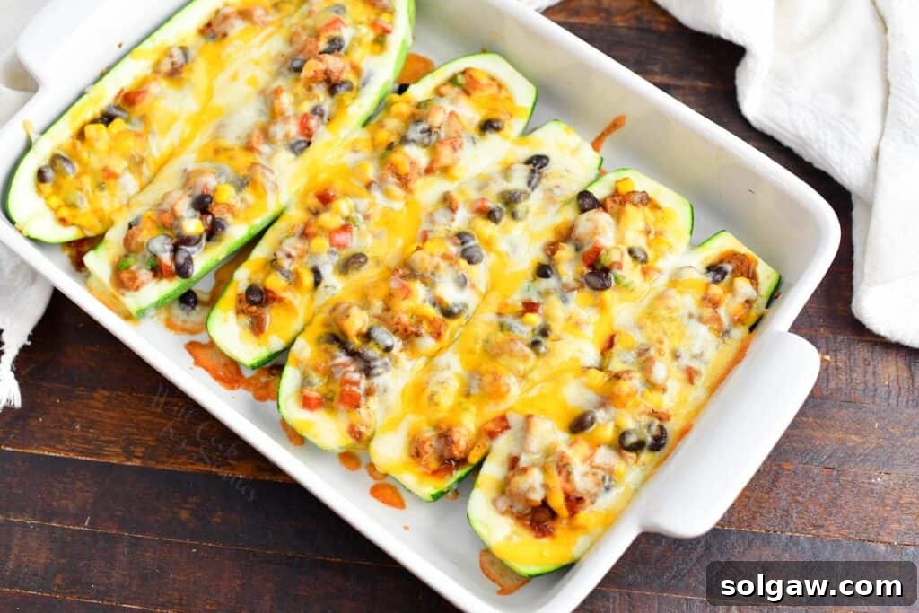 Zesty Southwest Chicken Zucchini Boats 11 Freshly baked Southwest Chicken Zucchini Boats served hot in a white baking dish, ready to eat.