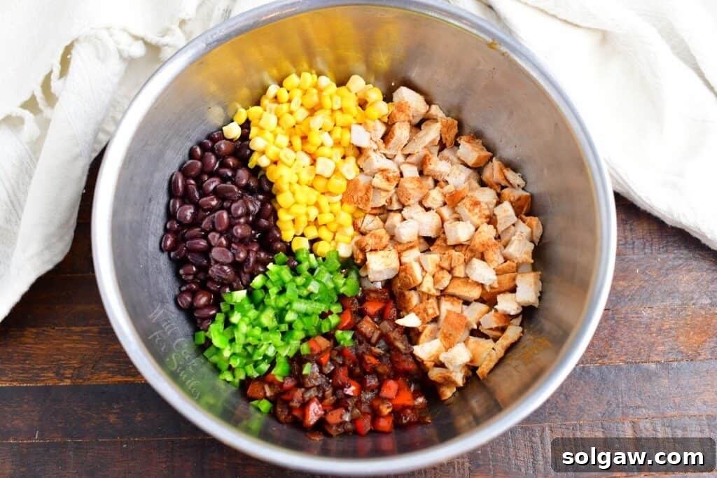 Zesty Southwest Chicken Zucchini Boats 7 All ingredients for the Southwest chicken filling mixed side by side in a large mixing bowl before stuffing the zucchini.
