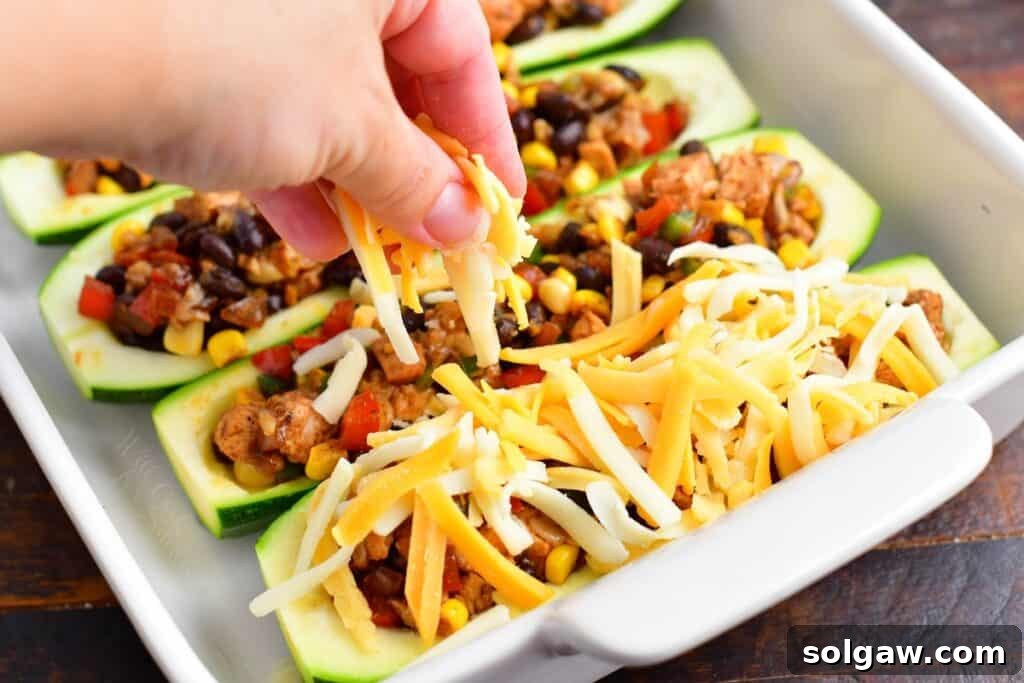 Zesty Southwest Chicken Zucchini Boats 10 Sprinkling shredded Mexican cheese over the stuffed zucchini boats before baking.