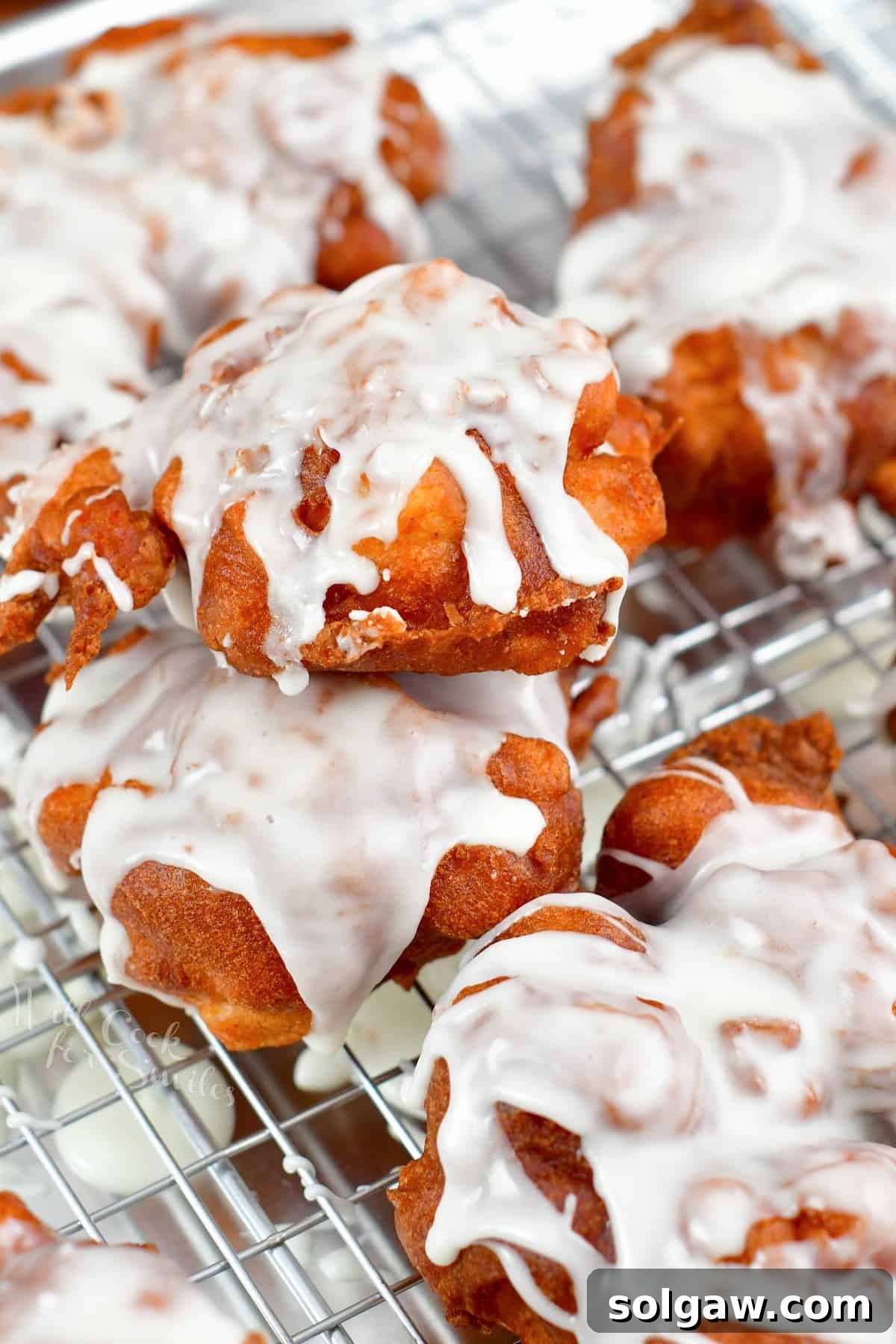 Golden Apple Delights 9 Stacked homemade apple fritters on a wire rack, ready to serve