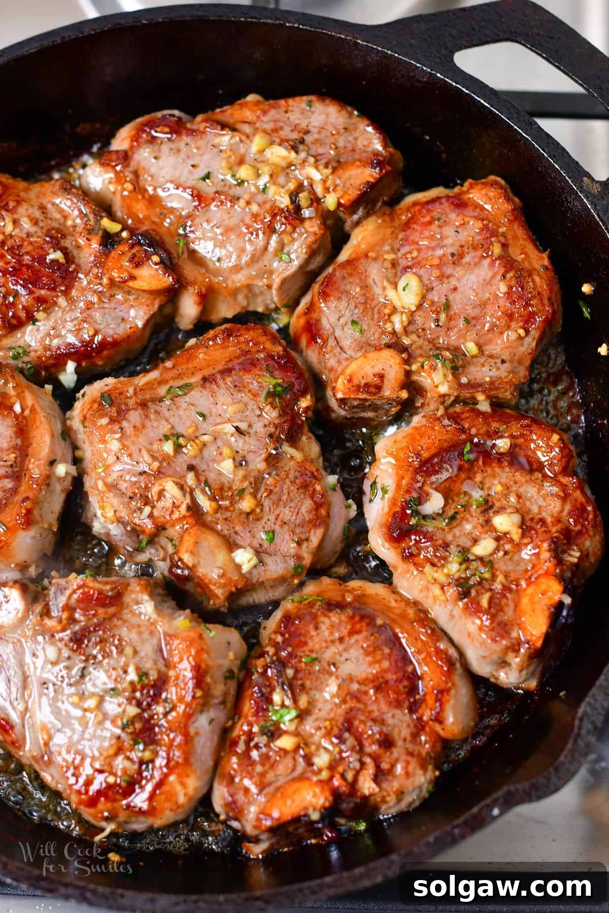 Perfectly pan-seared lamb chops in a cast iron skillet, garnished with fresh herbs, ready to serve.