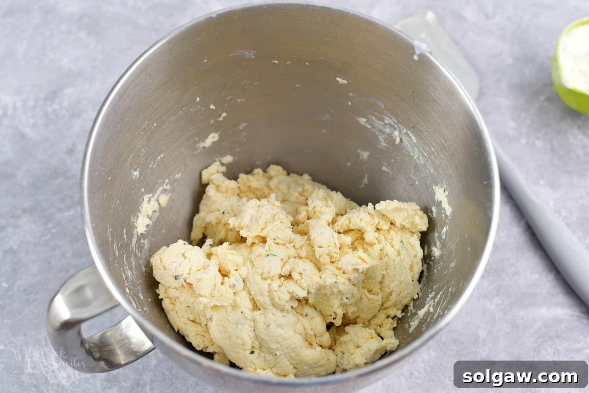 Parmesan Herb Garlic Butter Biscuits 3 Mixed biscuit dough in a stand mixer bowl, showing the crumbly texture before buttermilk is added.